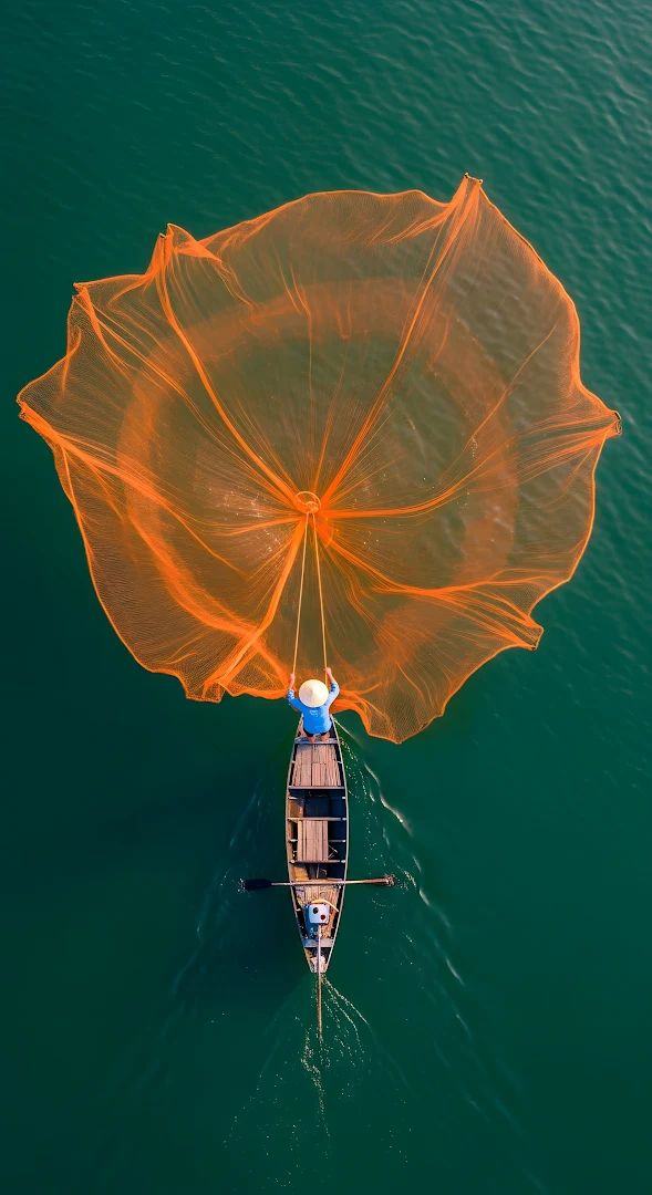 A fisherman casting a wide net from a small boat